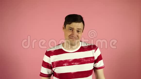 一个穿着粉红色背景条纹t恤的男人看着镜头说是视频的预览图