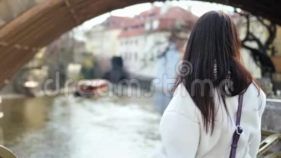 微笑的女游客欣赏来自城市堤岸的迷人河景视频的预览图
