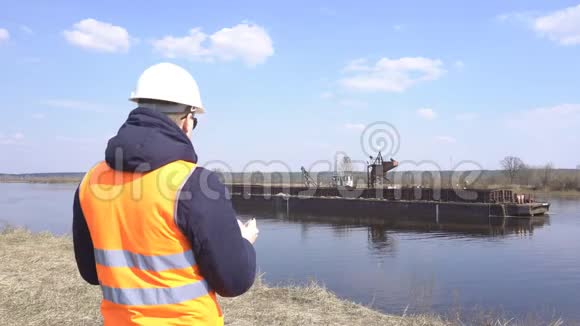 信号背心检查员监测建筑工业用河砂提取工作的质量视频的预览图