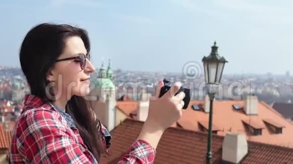 微笑女游客拍摄城市全景相机欣赏度假侧景视频的预览图