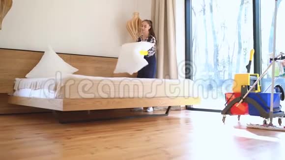 女清洁工在客厅铺床视频的预览图