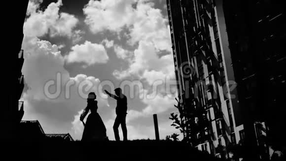 两个相爱的人在美丽的天空上跳舞的黑白剪影视频的预览图