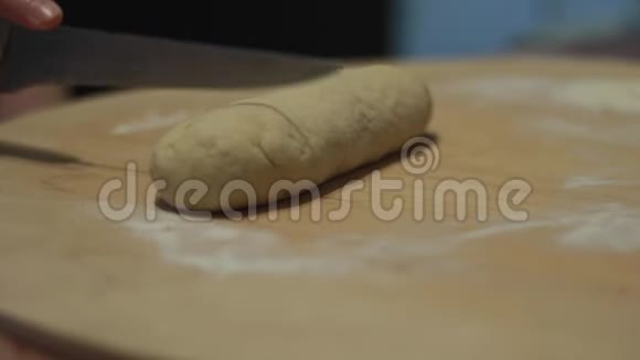 一个女人把一把刀切成碎片把披萨面团卷出来煮东西视频的预览图