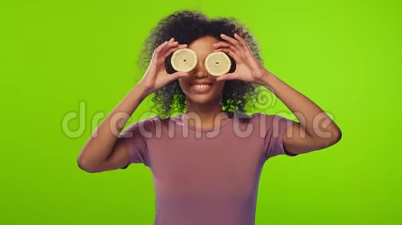 非洲女性正拿着一半的黄色柠檬做眼镜视频的预览图