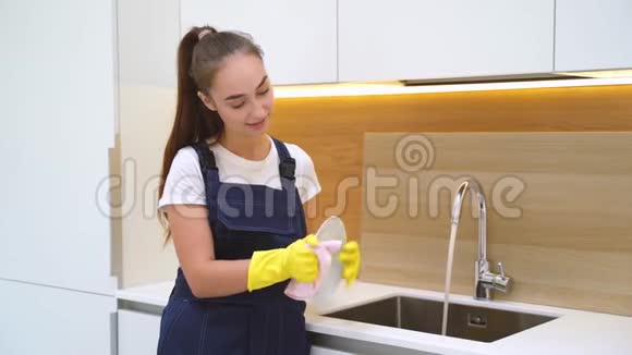 年轻女子在厨房擦陶瓷盘子视频的预览图