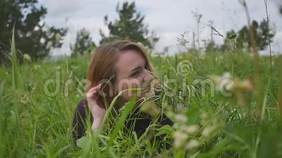 美丽的女孩躺在草地上做梦享受大自然吧关闭慢动作录像视频的预览图