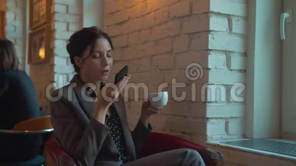 商务女性手里拿着一杯咖啡记录着一条语音信息视频的预览图