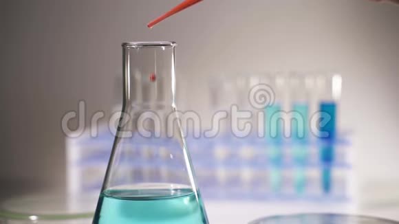 化验师将红色液体倒入试管中进行化学实验视频的预览图