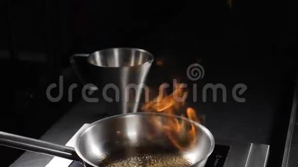煎锅上方大火焰的慢动作视图闭合油和酒精用明火点燃高清拍摄视频的预览图