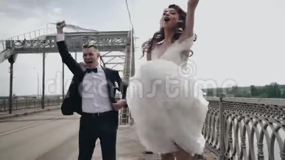 两个快乐的恋人在桥上跳着向汽车挥手视频的预览图