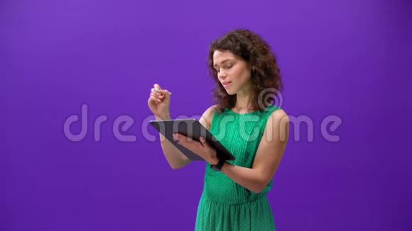 Curly女孩在一个紫色背景的手机上玩游戏视频的预览图