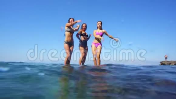 三个快乐的女孩在海上的栏杆上跳舞视频的预览图