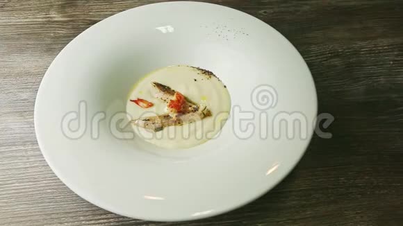 手旋转盘子配上美味的奶油汤配上大虾和炸鱼片视频的预览图