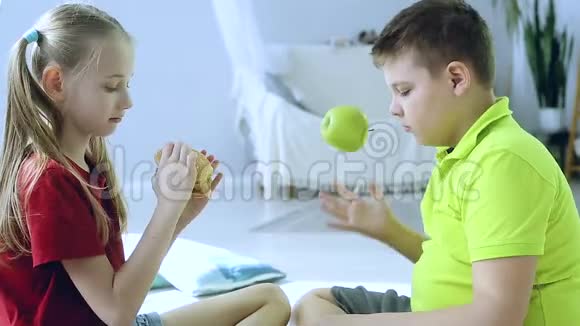 女孩吃汉堡男孩玩苹果视频的预览图