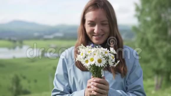 她拿着一束野花把它们拉进相机里视频的预览图