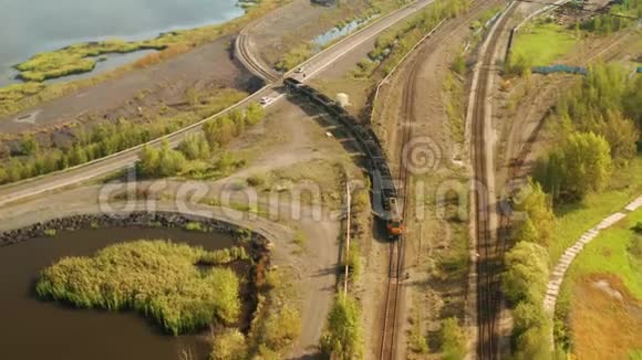 一列货运火车驶过一条环湖的通道视频的预览图