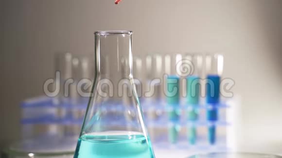 含有化学液体的玻璃器皿用于在实验室中研究或分析样品到试管中视频的预览图