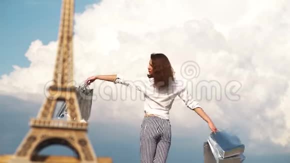 在天空和埃菲尔铁塔背景上有包裹的女孩漂亮的女人去巴黎购物购物视频的预览图