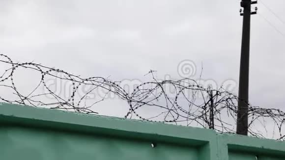 监狱里铁丝网的特写镜头带刺铁丝网的监狱带刺铁丝网的绿色围栏视频的预览图