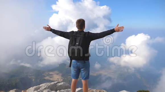 男孩游客站在山顶胜利地伸出手臂在夏季旅行中享受自由的家伙视频的预览图