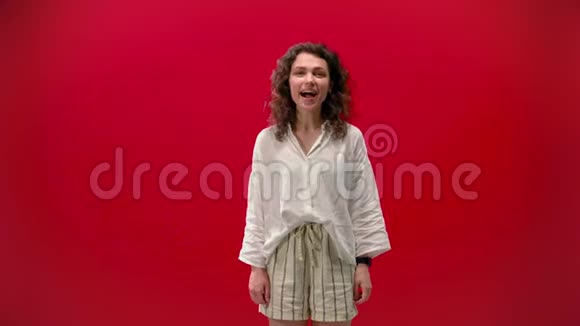 卷曲的女孩高兴的红色背景微笑视频的预览图