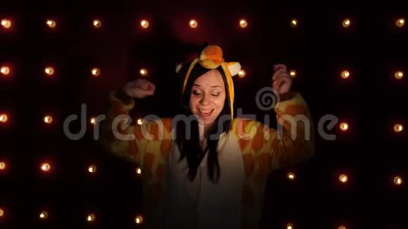 一个女人穿着明亮的孩子睡衣以长颈鹿的形式跳舞学生的情感肖像费用视频的预览图