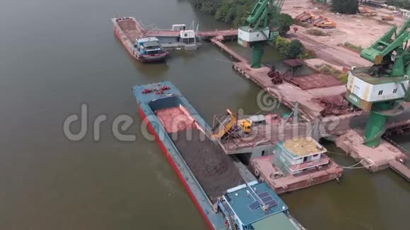 在小港口的驳船上装载建筑材料视频的预览图