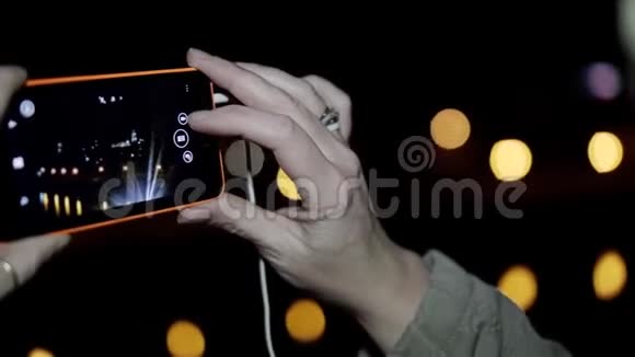 这个女孩在电话里拍夜景用手机特写女孩的手视频的预览图