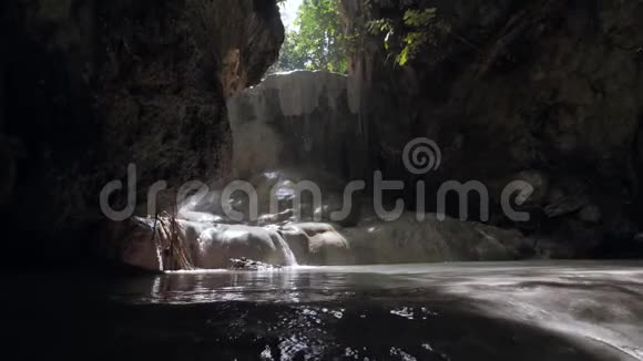 洞穴瀑布在岩石墙与水滴和流动的阳光视频的预览图