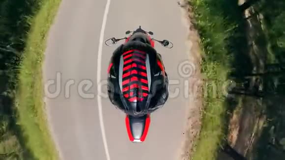 骑在森林道路上的摩托车手的俯视图摩托车在路上视频的预览图