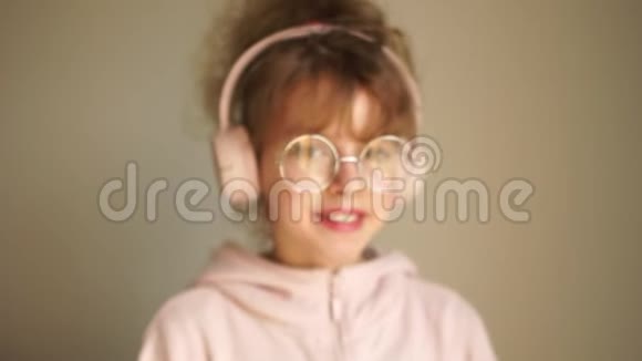 女孩用耳机听音乐和跳舞青年爱好美洛曼尼亚戴着耳机的少女画像视频的预览图