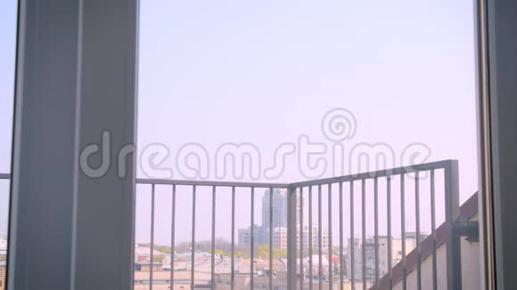 年轻的高加索夫妇相爱拥抱在阳台上欣赏壮丽的城市景色视频的预览图