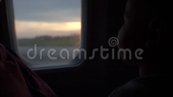 一个小男孩缓慢地看着窗外的舷窗视频的预览图