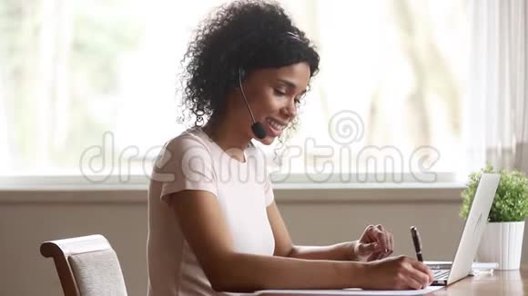 非洲女skype老师戴着耳机边说边看手提电脑视频的预览图