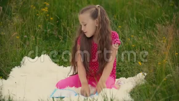 女孩坐在草坪上看书视频的预览图