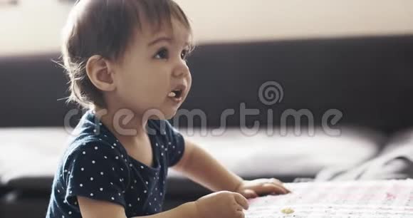 一个女婴玩耍时吃零食的肖像视频的预览图