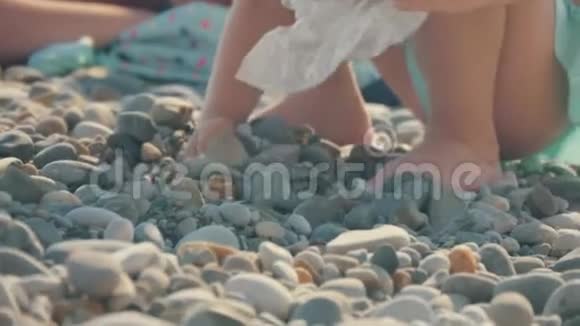 海岸上的一个孩子在玩石子孩子们的手收集鹅卵石儿童的发育和休息视频的预览图