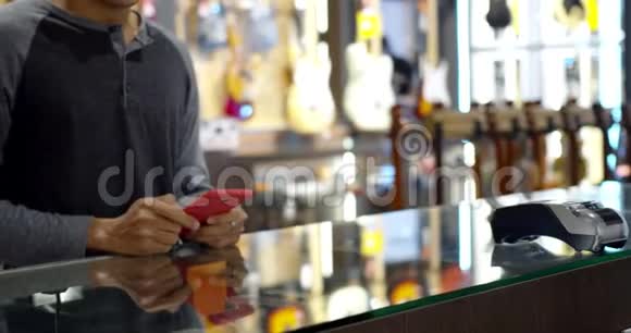 年轻的穆斯林使用智能手机支付非接触式交易机器视频的预览图