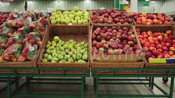 在超市购物一位年轻女子在商店的水果架上挑选苹果视频的预览图
