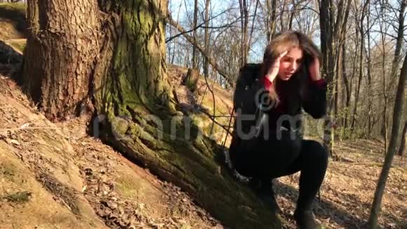 一个漂亮的女孩坐在一棵大树下女孩迷路了视频的预览图