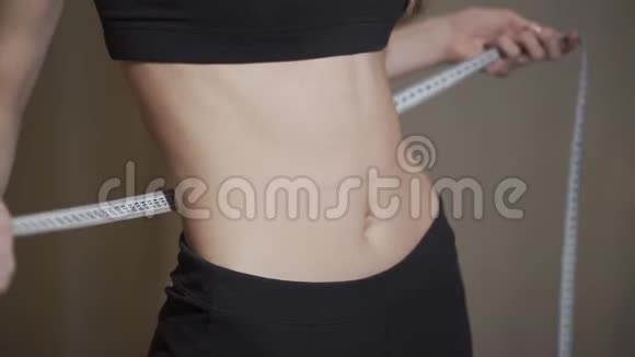 腰部测量一个女人用厘米胶带测量她的腰部视频的预览图