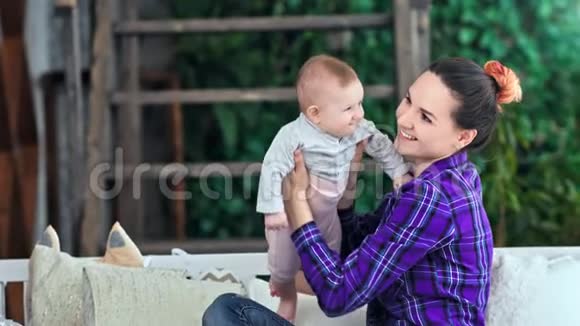 快乐的年轻妈妈把可爱的小宝宝扔在家玩中弹视频的预览图