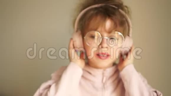一个戴着耳机戴着眼镜的十几岁女孩的肖像女孩用耳机听音乐跳舞视频的预览图