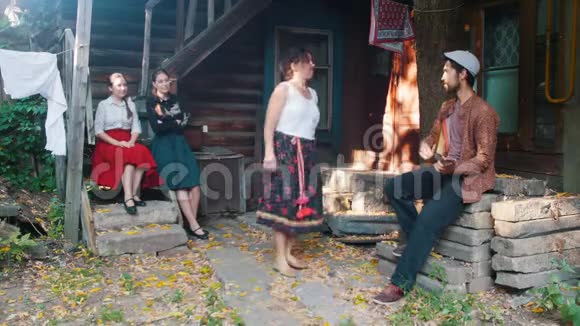 一个穿着五颜六色裙子的女人在音乐中跳舞一个男人在演奏巴拉莱卡视频的预览图