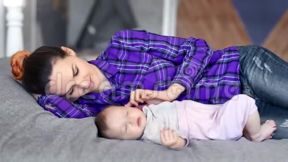 爱笑的母亲亲吻爱抚她熟睡的中号婴儿视频的预览图