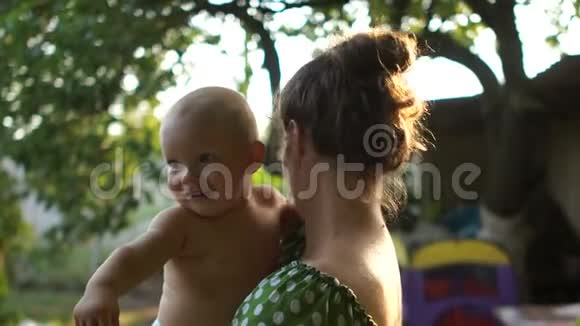 度假村花园里母亲和一岁婴儿的亲密肖像暑假妈妈天视频的预览图