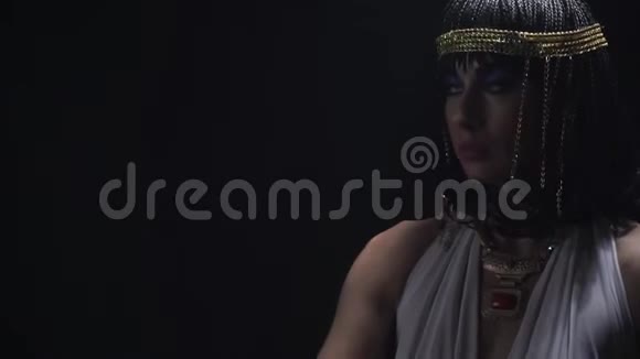 克利奥帕特拉在黑暗的房间里摆姿势戴着珠宝和蓝色的妆容视频的预览图