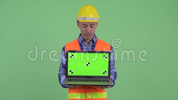 多民族建筑工人展示笔记本电脑视频的预览图