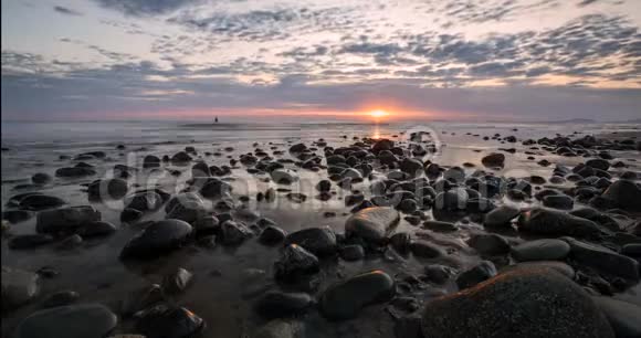 英国威尔士卵石滩上五彩缤纷的日落天空视频的预览图