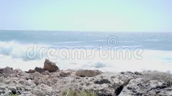 白种人有魅力的女人在岩石小径上奔跑海浪撞击海滩粉色服装视频的预览图